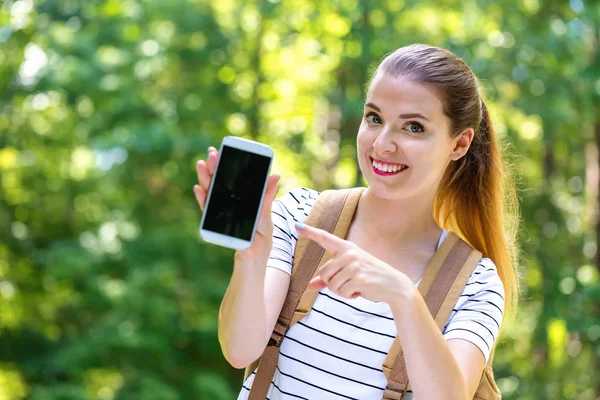 Wanita muda memegang sebuah smartphone — Stok Foto
