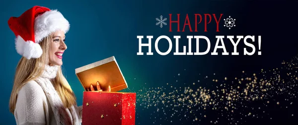 Happy holidays message with woman opening a gift box