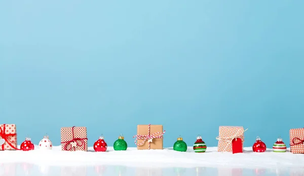 Christmas gift boxes in a snow covered landscape — Stock Photo, Image