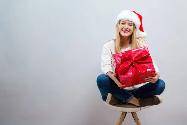 Mujer joven con sombrero de Santa sosteniendo una caja de regalo — Foto de Stock