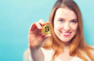 Fiziksel bir bitcoin tutan kadın