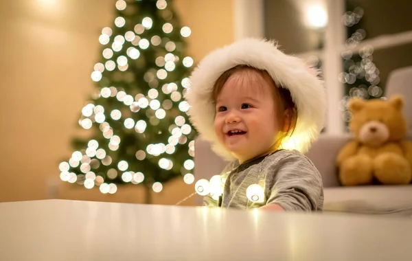 Tout-petit garçon jouant avec un chapeau de Père Noël au moment de Noël — Photo