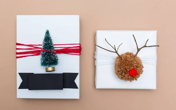 Renna pompon e scatole regalo albero di Natale in miniatura su marrone — Foto Stock