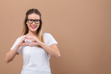 Woman making a heart shaped gesture clipart
