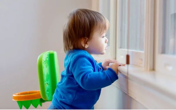 Μικρό παιδί αγόρι ψάχνει έξω από το παράθυρο — Φωτογραφία Αρχείου