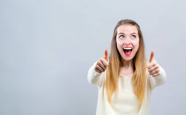 Young woman giving thumbs up