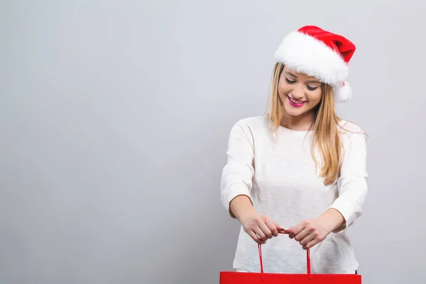 Giovane donna con cappello di Babbo Natale in possesso di una borsa della spesa — Foto Stock