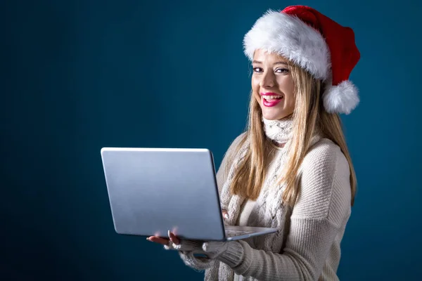 Jovem com chapéu de Papai Noel usando seu laptop — Fotografia de Stock
