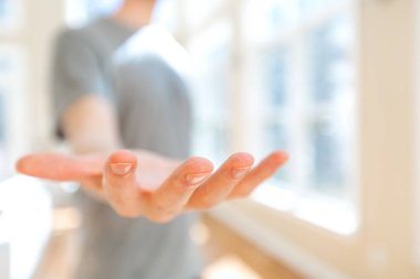 Adam elini uzatarak ve bir şeyler gösteriyor