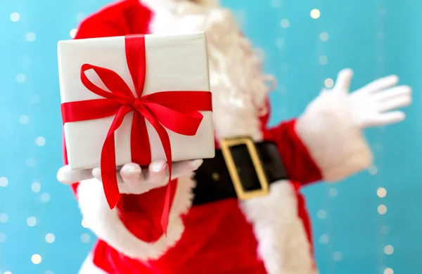 Santa hålla en julklapp — Stockfoto
