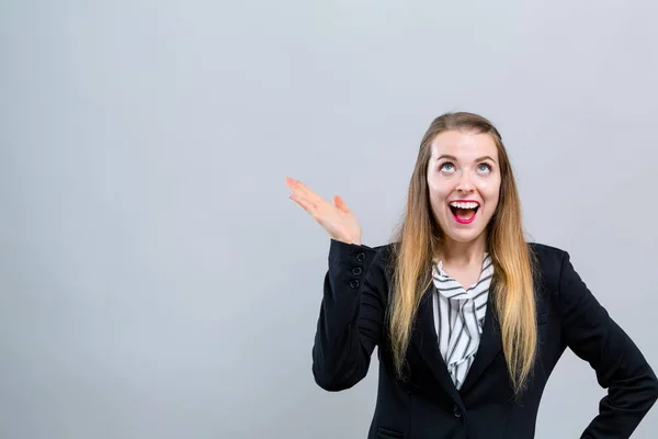 Mujer joven alcanzando y mirando hacia arriba — Foto de Stock