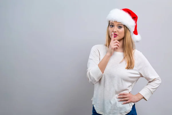 Junge Frau mit Weihnachtsmütze macht eine ruhige Geste — Stockfoto