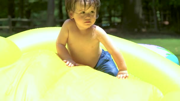 Feliz niño jugando en su piscina del patio trasero — Vídeo de stock