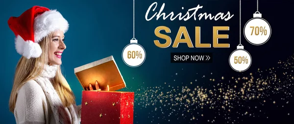 Christmas sale message with woman opening a gift box — Stock Photo, Image