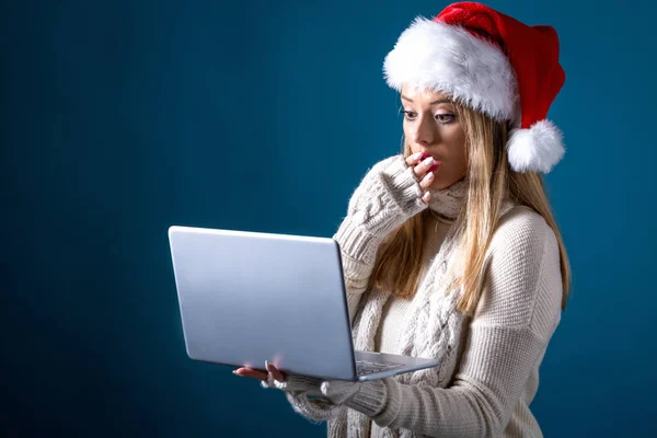 Jovem com chapéu de Papai Noel usando seu laptop — Fotografia de Stock