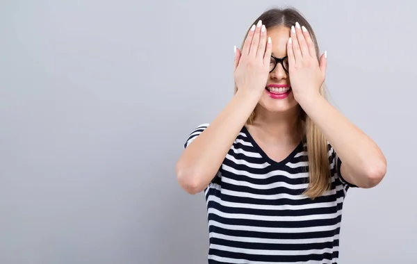 Frau bedeckt ihre Augen mit ihren Händen — Stockfoto