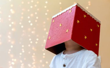 Kafasında bir Noel hediyesi ile oynarken yürümeye başlayan çocuk