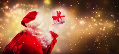 Santa holding a Christmas gift clipart