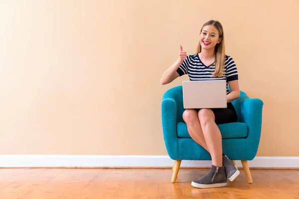 Giovane donna con un computer portatile che dà pollice in su — Foto Stock