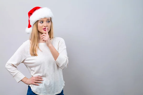 Junge Frau mit Weihnachtsmütze macht eine ruhige Geste — Stockfoto