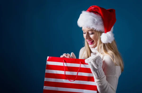 Giovane donna con cappello di Babbo Natale in possesso di una borsa della spesa — Foto Stock