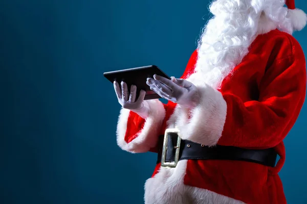 Santa hålla en surfplatta — Stockfoto