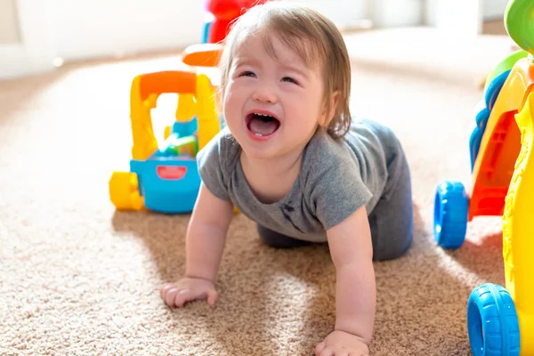 Плачущий малыш играет со своими игрушками — стоковое фото