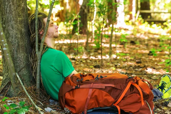Escursionista con zaino che dorme contro un albero — Foto Stock