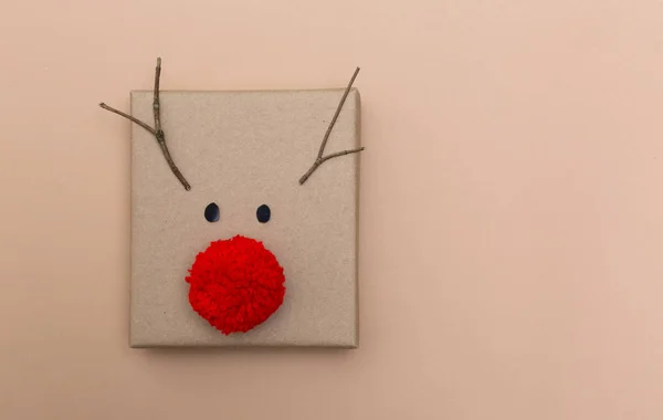 Pompom reindeer gift box on brown paper — Stock Photo, Image