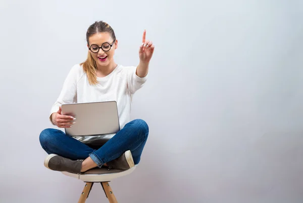 Mujer joven con un ordenador portátil apuntando algo —  Fotos de Stock