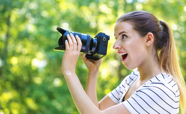Ung kvinna med en professionell kamera — Stockfoto