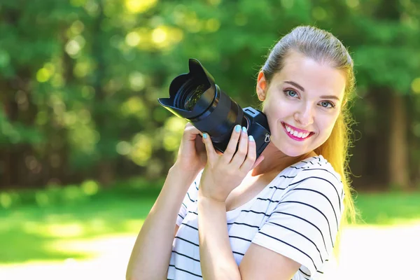 Giovane donna con una fotocamera professionale — Foto Stock