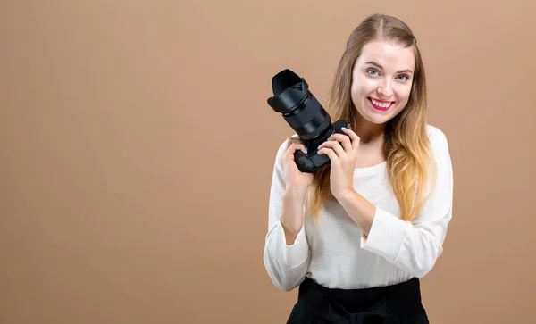 Giovane donna con una fotocamera professionale — Foto Stock