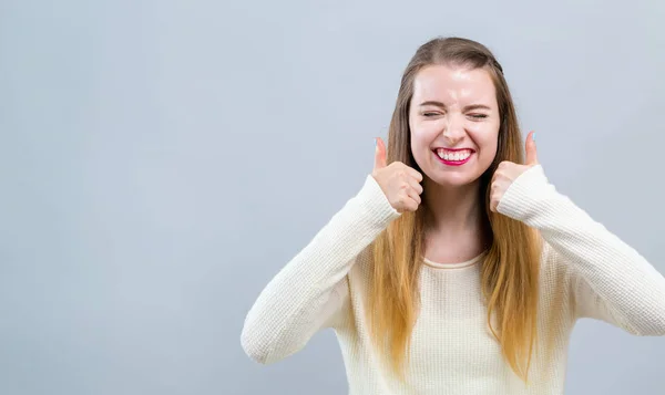 Jonge vrouw geeft duimen op — Stockfoto