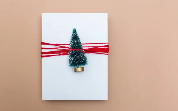 Мініатюрна подарункова коробка ялинки на коричневому папері — стокове фото
