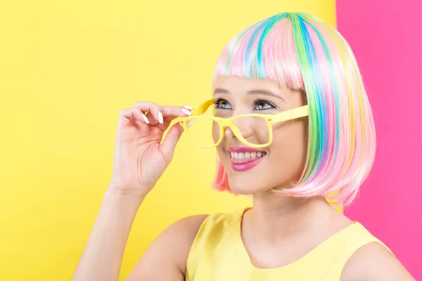 Kobietę w okularach przeciwsłonecznych w kolorowe peruki — Zdjęcie stockowe