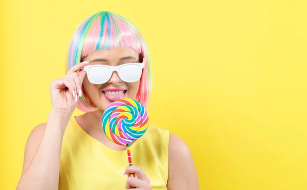 Woman in a colorful wig with a lollipop — Stock Photo, Image