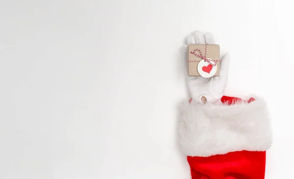 Santa segurando um pequeno presente de Natal — Fotografia de Stock