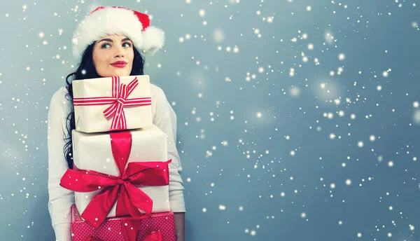 Jeune femme avec chapeau santa tenant des boîtes-cadeaux — Photo