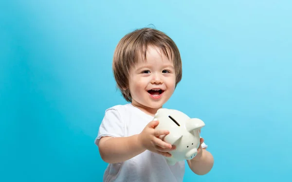 Toddler boy with a piggy bank — Stock Photo, Image