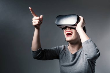 Sanal gerçeklik kulaklığı kullanan genç bir kadın.