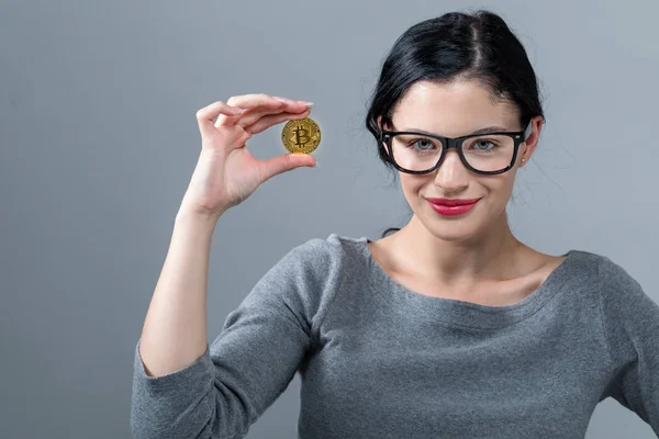 Genç kadın bir altın bitcoin para ile — Stok fotoğraf