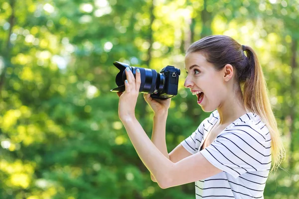 Jeune femme avec une caméra professionnelle — Photo