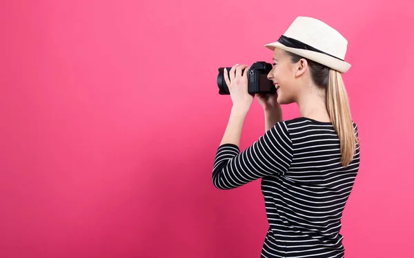 Jeune femme avec une caméra professionnelle — Photo