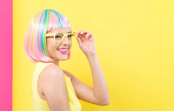 Mulher usando óculos de sol em uma peruca colorida — Fotografia de Stock