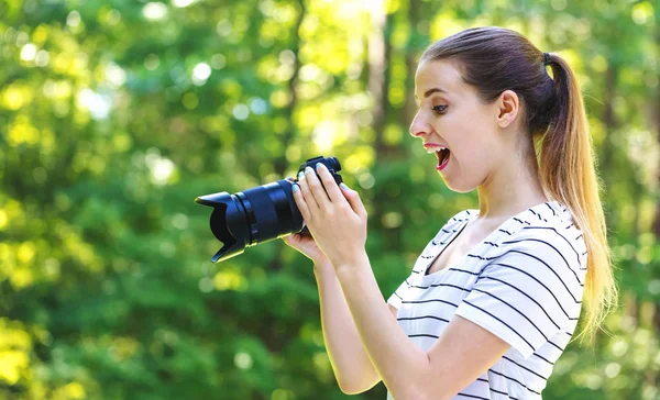 Jeune femme avec une caméra professionnelle — Photo