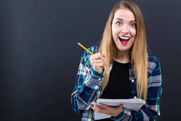 Mujer joven con cuaderno y lápiz — Foto de Stock