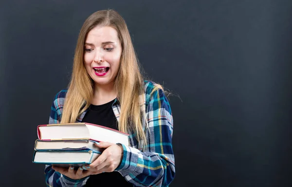 Triste jovem estudante com pilha de livros didáticos — Fotografia de Stock