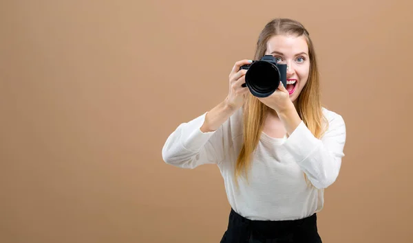Giovane donna con una fotocamera professionale — Foto Stock