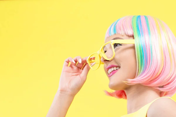 Kobietę w okularach przeciwsłonecznych w kolorowe peruki — Zdjęcie stockowe
